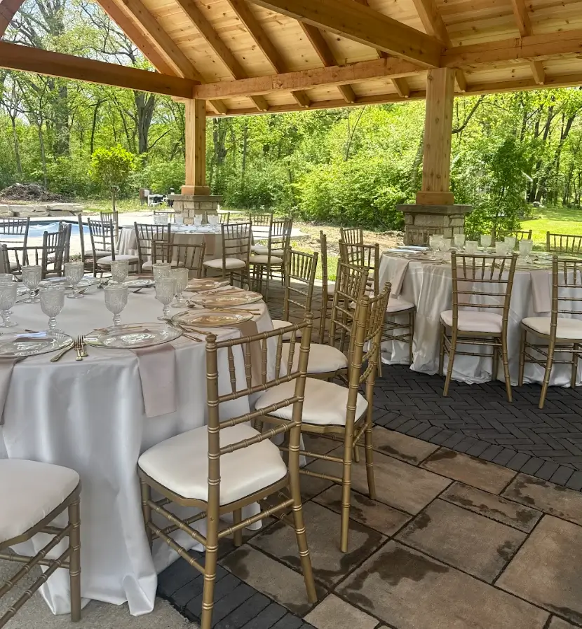 Full event setup with gold chiavari chairs satin linens and tableware rentals Chicagoland IL